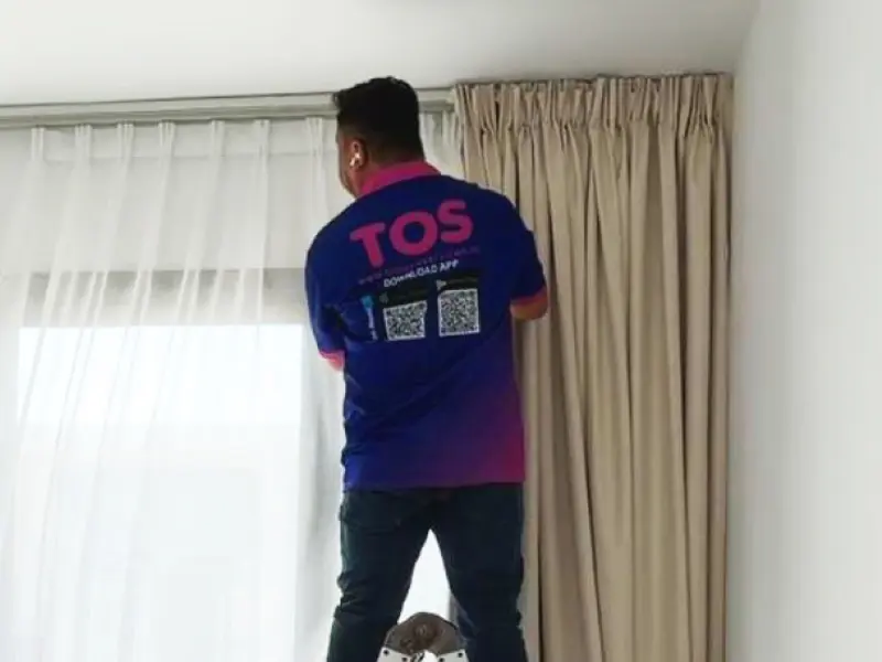 A TopOne cleaner cleaning curtains on site while they hang