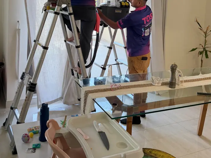 TopOne cleaner on a ladder cleaning curtains